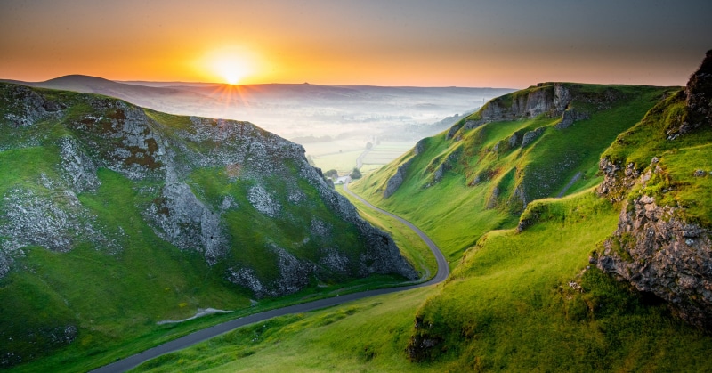 Sunrise over a valley road in the Peak District, England