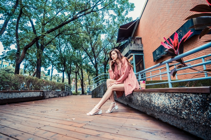 Asian woman sitting on a bench outdoors