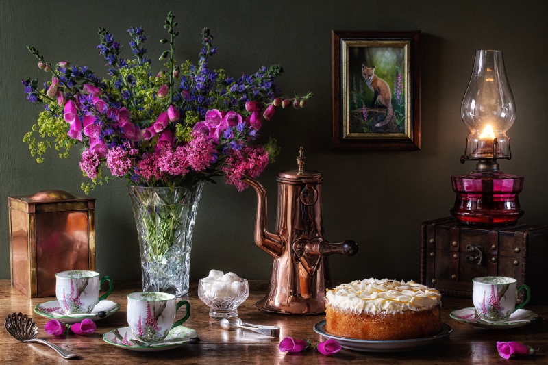 Still life with cake, flowers, and kerosene lamp