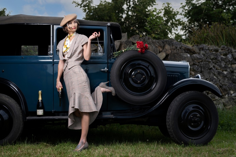 Woman in Retro Outfit with Champagne and Pistol