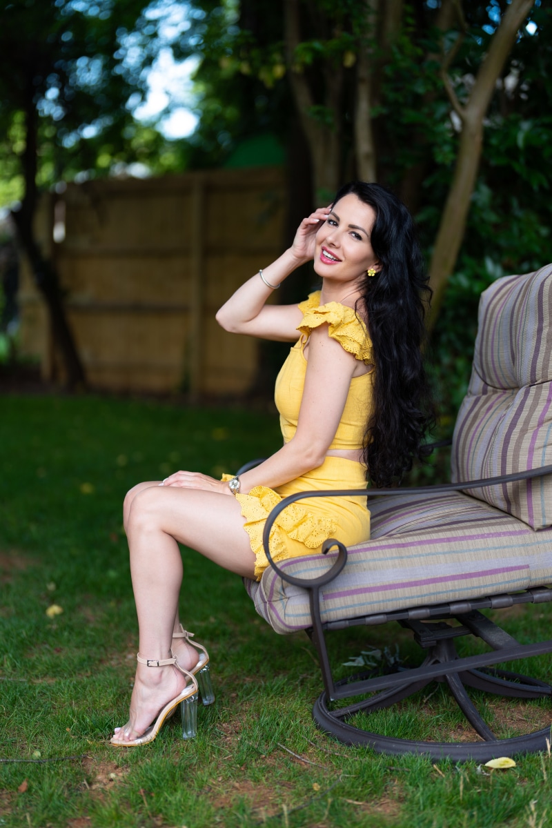 Brunette woman in yellow outfit sitting on armchair