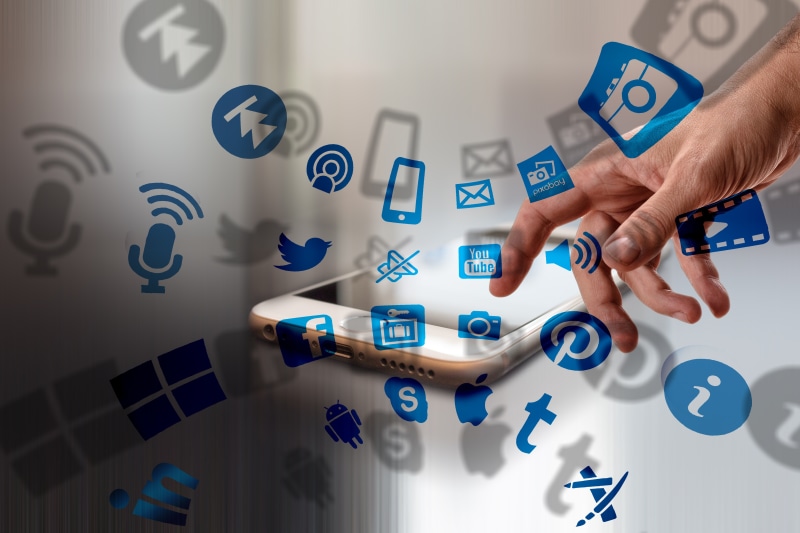 Smartphone with social media icons and hand