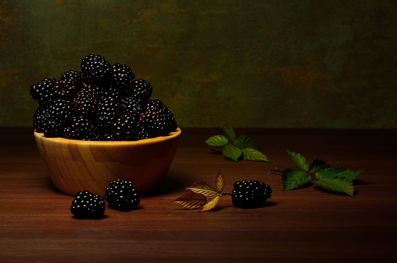 Blackberries in a bowl with leaves
