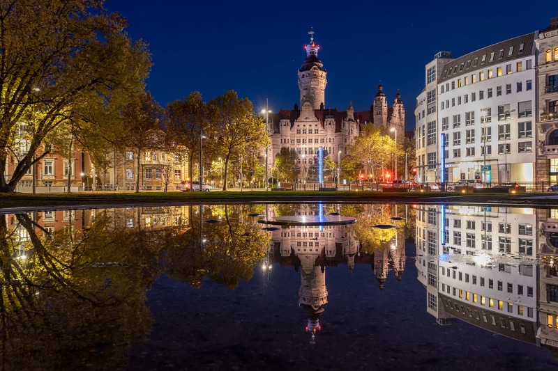 New City Hall reflected in a puddle at night in Leipzig, Germany