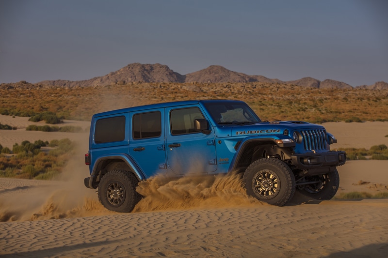 Blue Jeep Wrangler Unlimited Rubicon 392 driving on sand