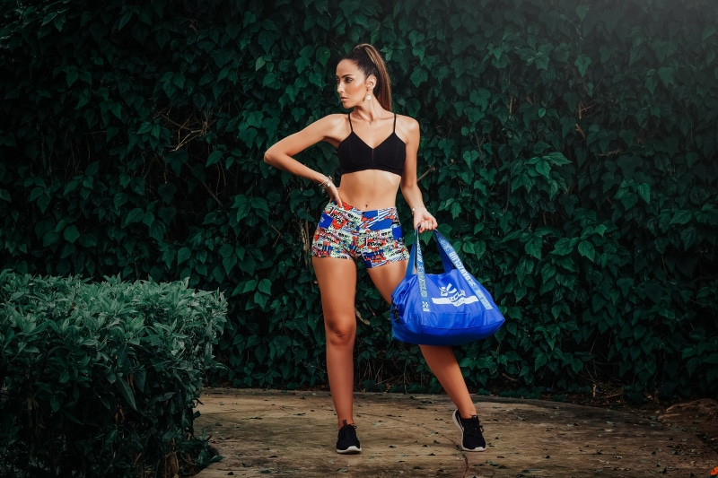 Woman in athletic wear holding a blue bag
