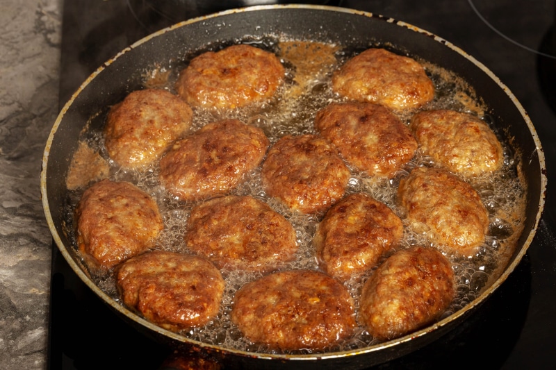 Frikadeller frying in a pan