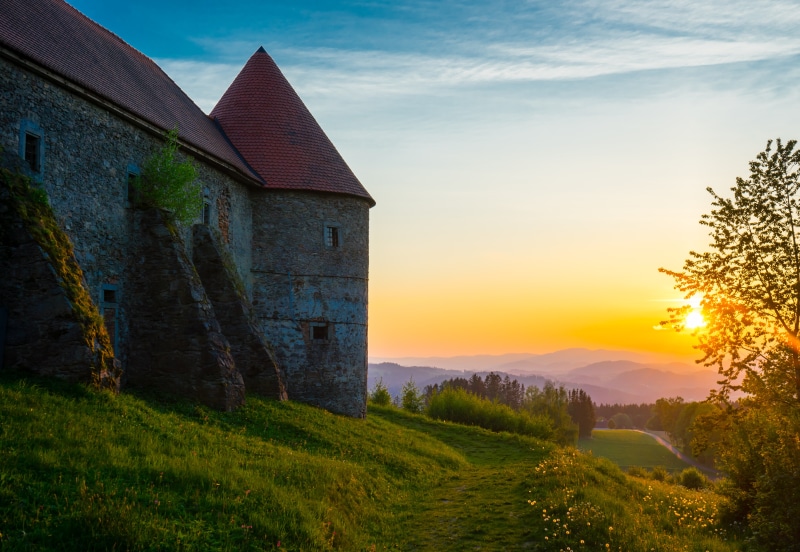 Piberstein Castle at sunrise with rolling hills