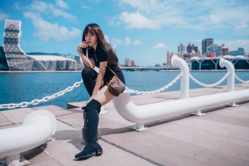 Asian woman sitting by the waterfront