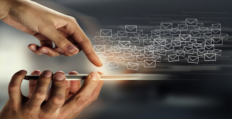 Hands using smartphone sending email messages