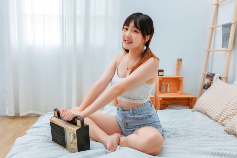 Asian girl with radio on bed