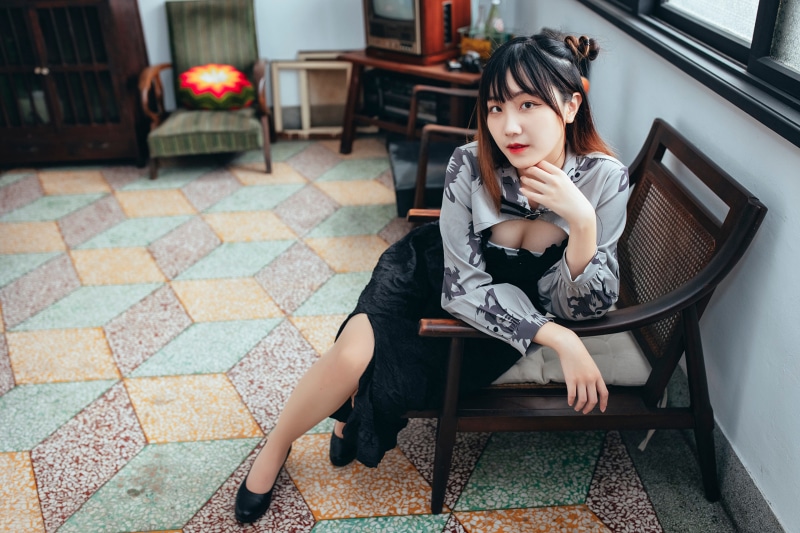 Asian woman sitting in a vintage armchair