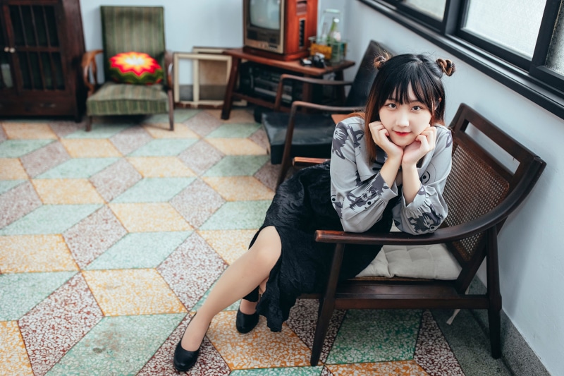 Asian woman sitting in a vintage armchair