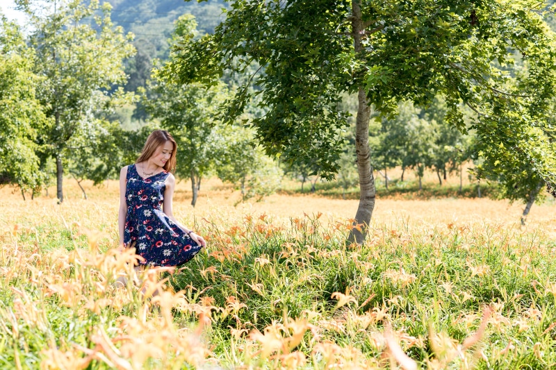 Asian woman in a floral dress in a field of flowers