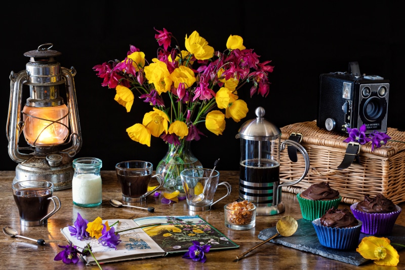 Still-life with Kerosene lamp, coffee, cupcakes, and flowers
