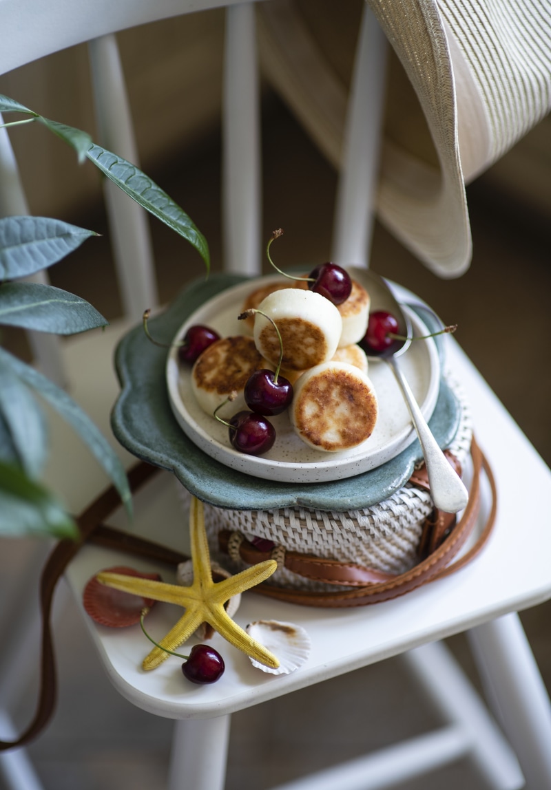 Syrniki with cherries on a chair