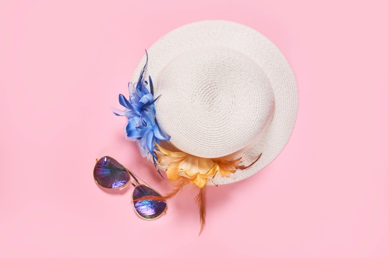 White hat with blue and orange flowers and sunglasses