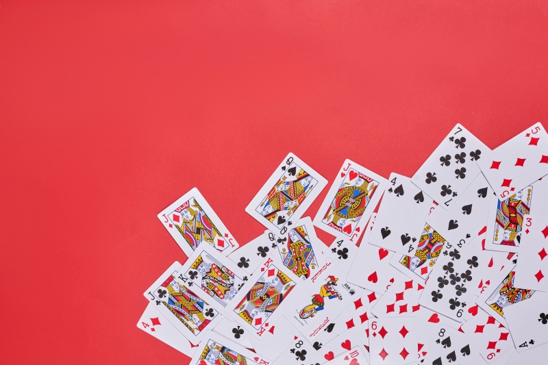 Many playing cards scattered on a red background