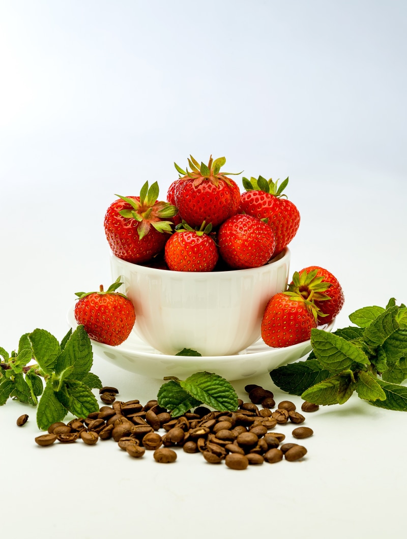 Strawberries and coffee beans with mint leaves