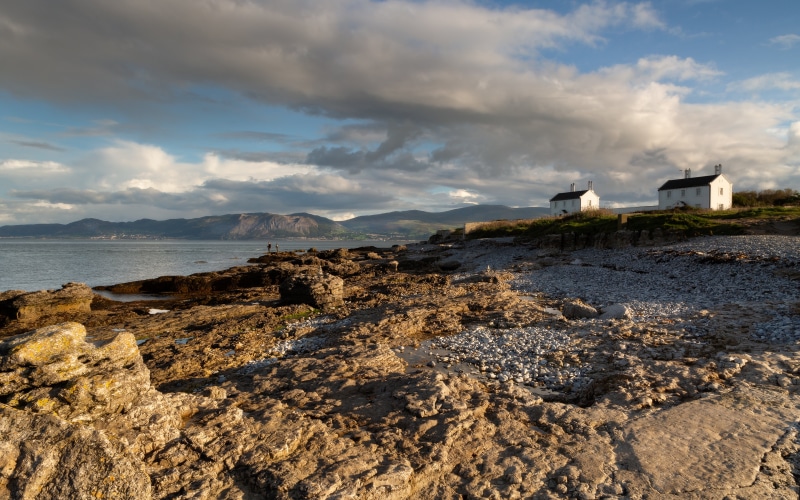 Two white houses on a rocky coast in Wales