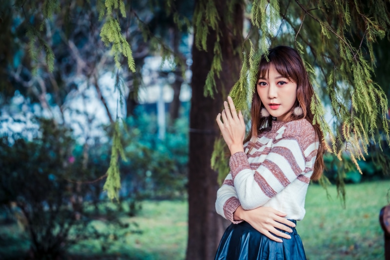 Asian woman with branches in foreground