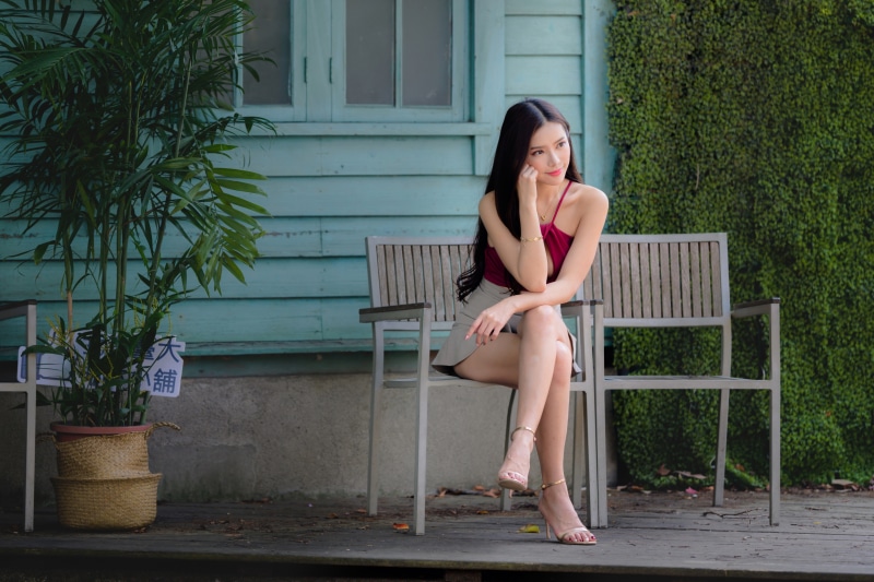 Asian woman sitting on a bench outdoors