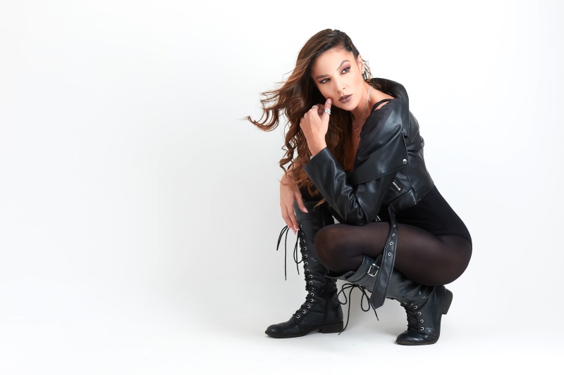 Woman in black jacket and boots posing