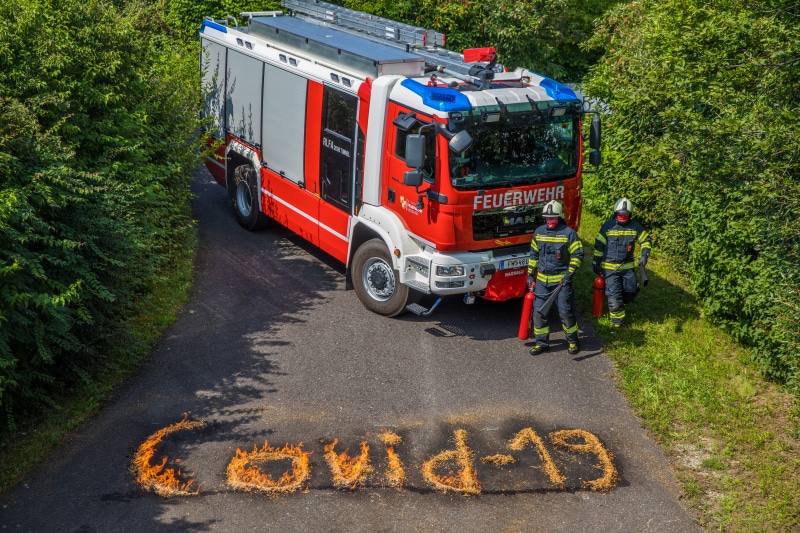 Firefighters and fire engine with COVID-19 text on fire