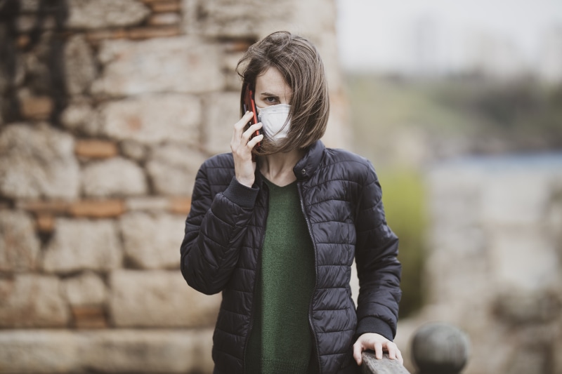 Woman wearing mask talking on phone