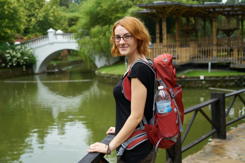 Woman with Red Hair and Backpack in Park