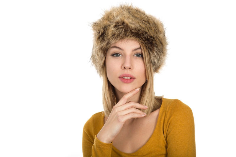 Blonde girl in winter hat on white background