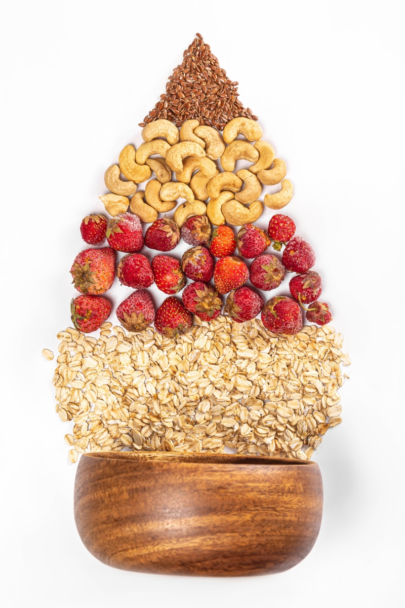 Oatmeal, strawberries, cashews, and flax seeds arranged in a bowl