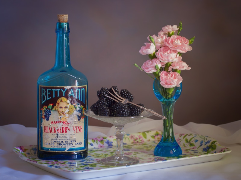 Betty Ann Blackberry Wine bottle with flowers and blackberries