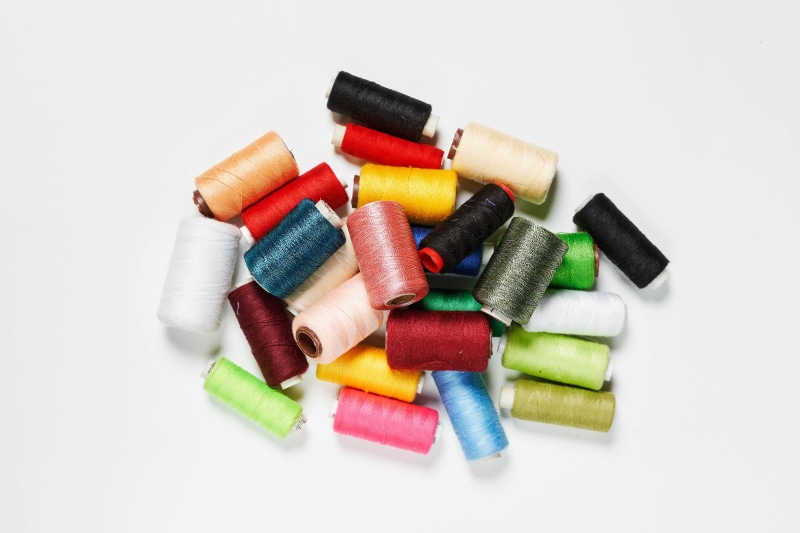 Multicolor spools of thread on a gray background