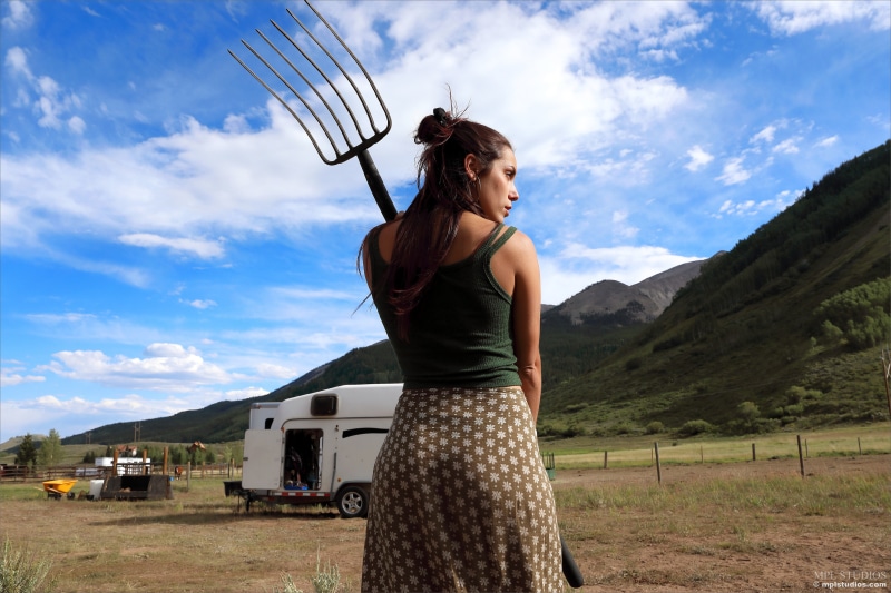Elena Generi with Pitchfork in Rural Landscape