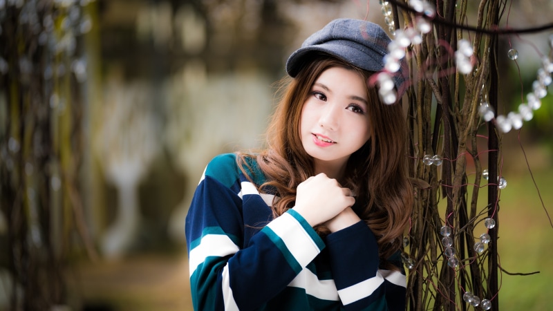 Asian woman with brown hair wearing a baseball cap