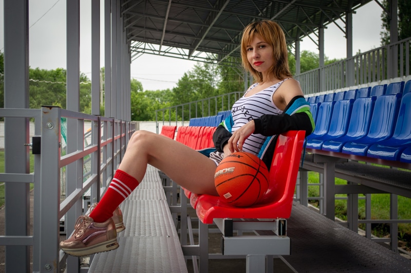 Victoria Borodinova with a basketball on stadium seats