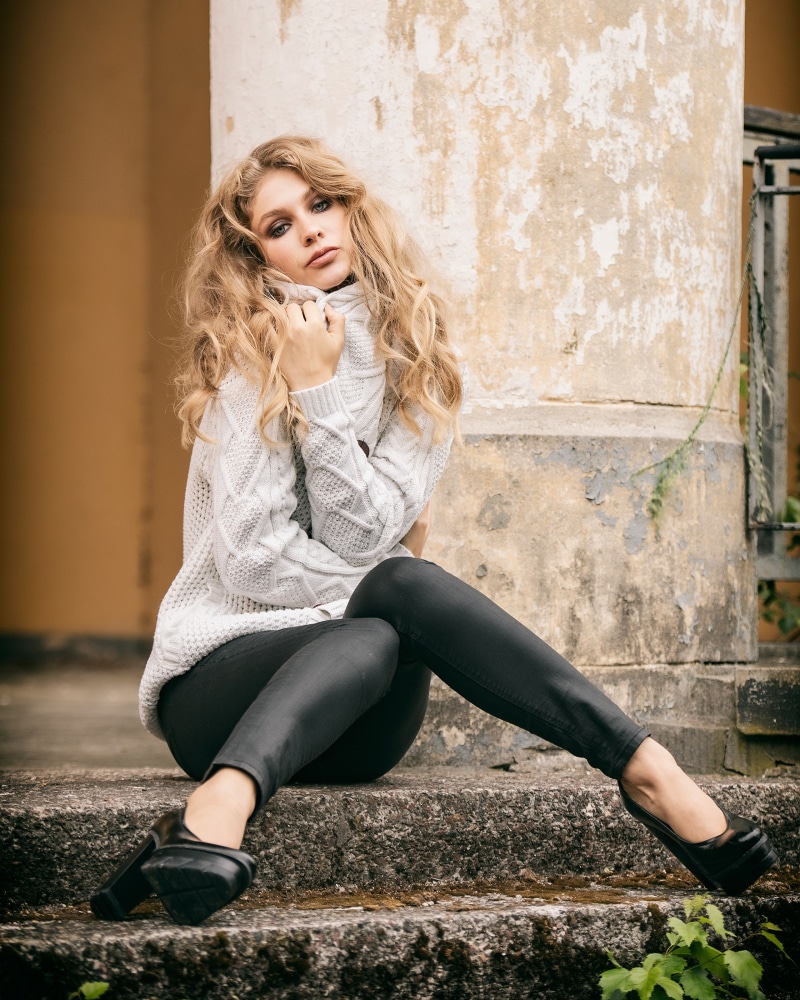 Blonde girl Sladjana sitting on steps in a sweater