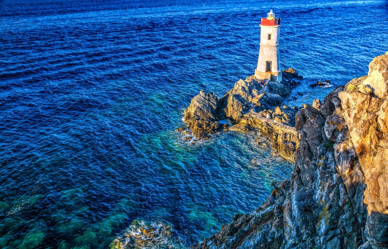Lighthouse on a rocky island in the sea, Sardinia, Italy