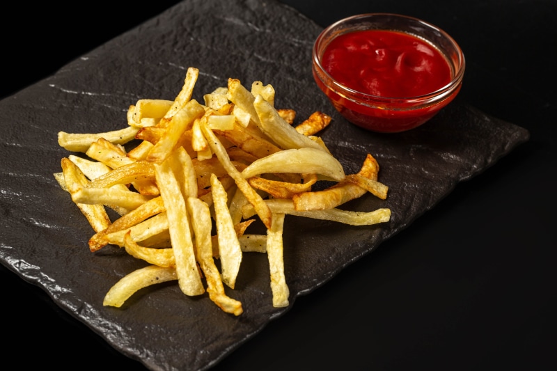 French fries with ketchup on a slate plate