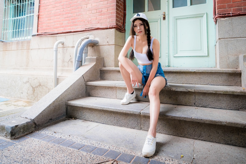 Asian woman in shorts and singlet on stairs
