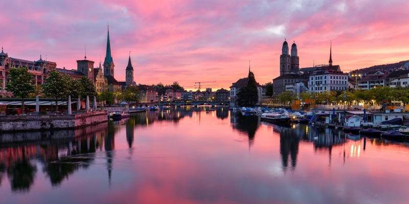 Zurich skyline with river and pink sunset sky