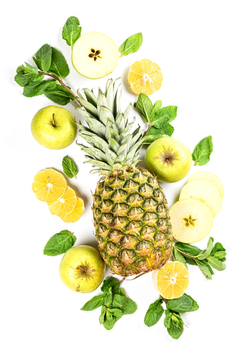 Pineapples, Apples, Orange Fruit, and Mint on White Background