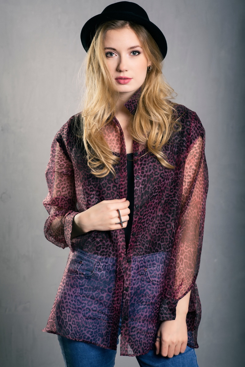 Blonde girl wearing a hat and leopard print shirt