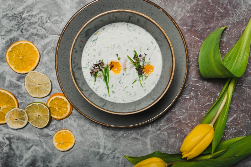 Cold soup with citrus slices and tulips