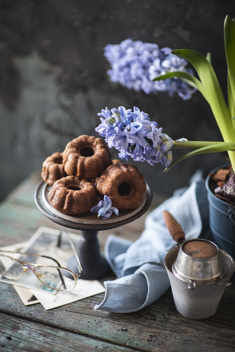 Bundt cakes with hyacinths and glasses on wooden planks