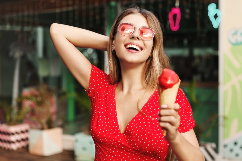 Woman in red polka dot dress eating ice cream