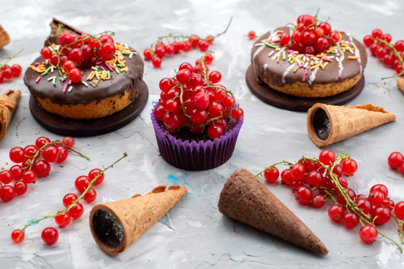 Chocolate donuts and cupcakes with currants and ice cream cones