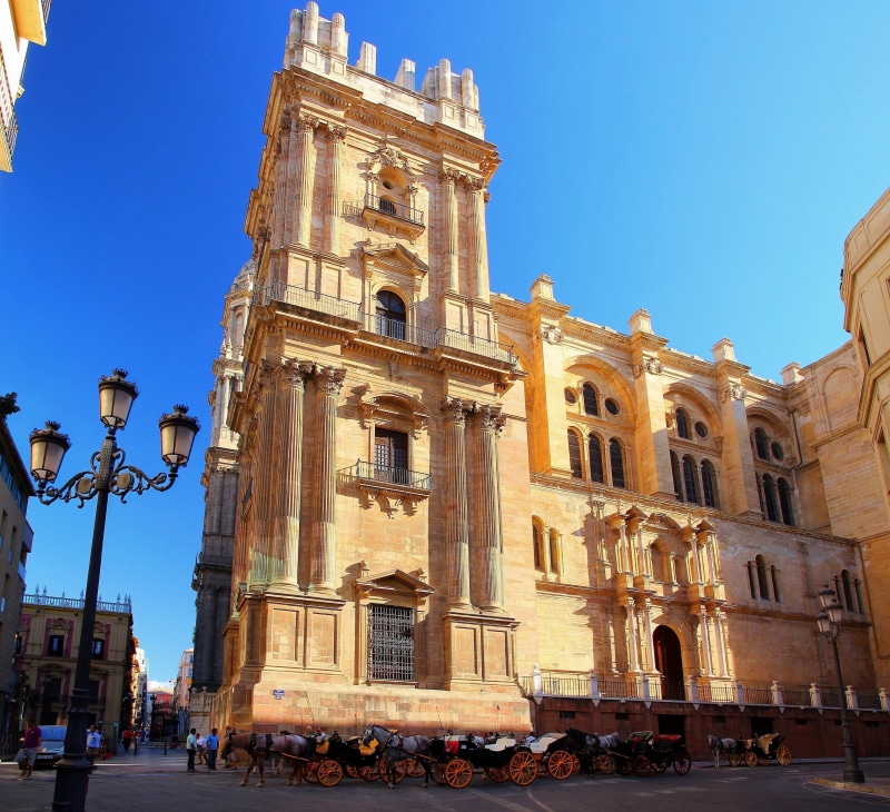 Malaga Cathedral with horse-drawn carriages on street