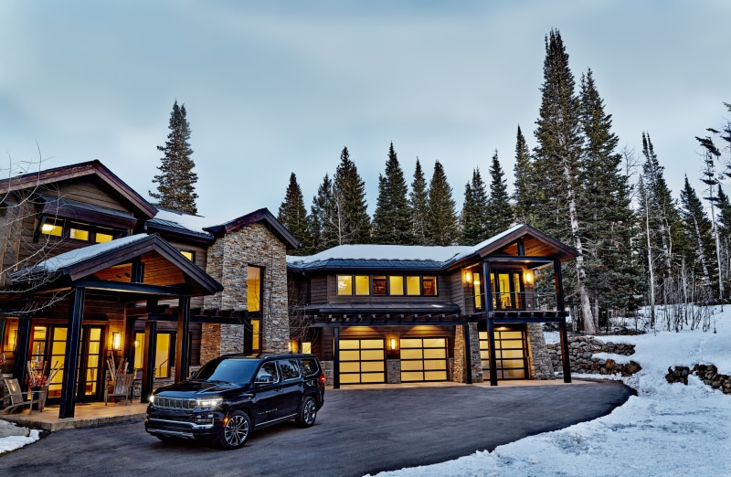 2021 Grand Wagoneer Series III SUV in front of a modern mountain home
